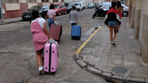 Varias de las menores marroquíes devueltas de Palencia a Melilla cargan con sus maletas en la ciudad autónoma.- JOSÉ PALAZÓN/PRODEIN