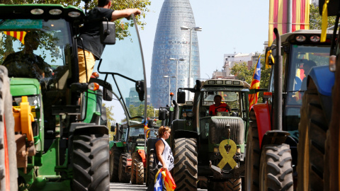 Una mujer camina entre tractores el día de la Diada en Barcelona, que está marcado por un clima político cargado. /  REUTERS - ENRIQUE CALVO