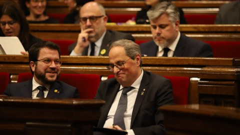 El vicepresident i el president de la Generalitat, Pere Aragonès i Quim Torra, somriuen en els seus escons durant un ple extraordinari convocat després de la decisió de la Junta Electoral Central (JEC) d'inhabilitar Torra. Pau Venteo / Europa Press