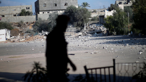 Un miembro de las fuerzas de seguridad palestinas de Hamas camina frente a las ruinas de un edificio tras un ataque aéreo israelí. / REUTERS - MOHAMMED SALEM