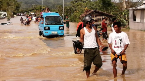 Ormoc (Filipinas), 25/12/2019.- Gente anda por el agua en una carretera inundada el día de Navidad en la ciudad de Ormoc, Filipinas, azotada por el tifón Phanfone, el 25 de diciembre de 2019. El tifón Phanfone (conocido localmente como Ursula) tocó ti