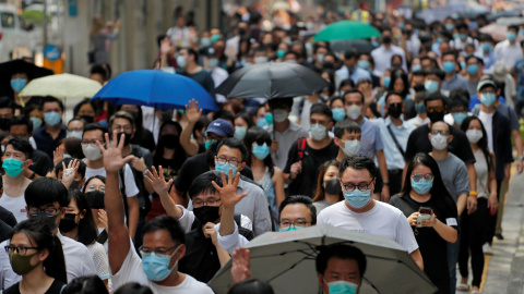 Cientos de personas marchan en el centro de Hong Kong para protestar contra los abusos policiales. / Reuters