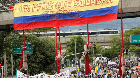 Cuatro artistas colgados de un puente en Medellín, Colombia, en una performance protesta por la violencia del país (DAVID ESTRADA / Reuters)