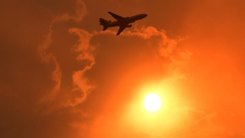 Un avión cisterna DC-10 rocía con un líquido retardante una zona en llamas durante un incendio forestal declarado en North Nowra, Australia. | EFE