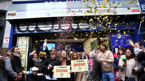 Un grupo de personas celebran en la administración madrileña de Doña Manolita que ha vendido el número 26.590. EFE/Rodrigo Jiménez.