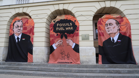 Varsovia (Polonia), 25/05/2022.- Pancartas que muestran al primer ministro húngaro, Viktor Orban (L), al presidente ruso, Vladimir Putin (R), y al lema 'Guerra de combustibles fósiles' durante una protesta de Greenpeace exigiendo un boicot al petróleo 