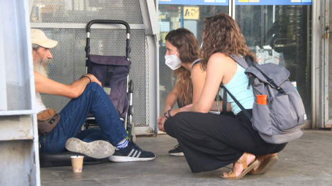 14/08/2021 - Dues treballadores de la Fundació Arrels atenen una persona sense llar a la Barceloneta, en una imatge del 2021.