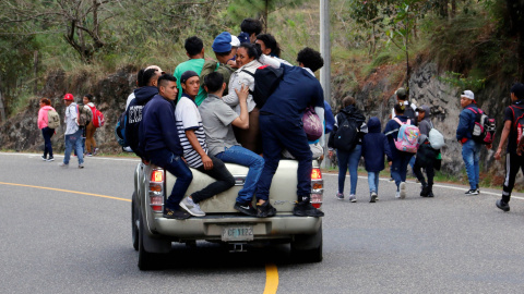 Uno de los migrantes durmiendo arropado por la bandera de Honduras. / Reuters