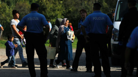 Agentes de la Policía croata escolta na varios migrantes. - REUTERS