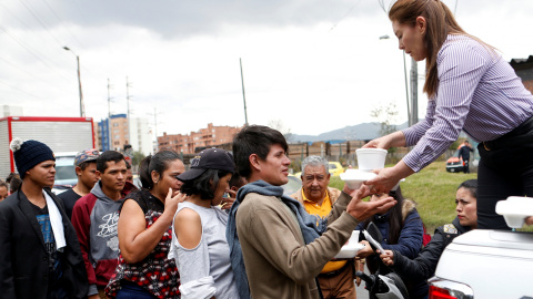 Migrantes venezolanos reciben comida de voluntarios colombianos en la estación de Bogotá, Colombia.- REUTERS/Luisa Gonzalez