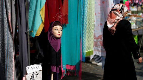 Una mujer con velo pasa junto a una tienda de venta de pañuelos en una imagen de archivo. / REUTERS - FRANCOIS LENOIR