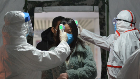 29/01/2020.- Trabajadores de una estación de ferrocarril toman la temperatura a los pasajeros en Fuyang (China). / EFE