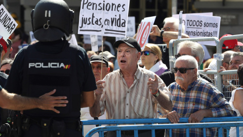 Grupos de pensionistas que se concentraron en el Congreso de los Diputados pidiendo mejoras en sus prestaciones intentan romper el cordón policial intentaba impedir su paso hasta la cámara donde hoy estaba prevista una reunión del Pacto de Toledo. EFE/