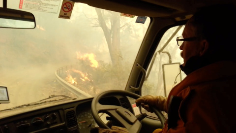 31/12/2019 - Los bomberos atraviesan las llamas durante la evacuación después de que los incendios se volvieran demasiado fuertes, Jenolan Caves, Nueva Gales del Sur, Australia. / JENOLAN CUEVAS (REUTERS)