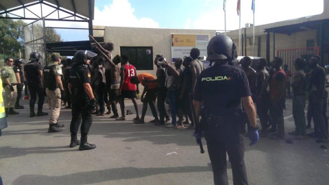 Migrantes custodiados por efectivos de la Policía Nacional esperan su entrada al Centro de Estancia Temporal de Inmigrantes (CETI) de Ceuta, tras conseguir saltar la valla fronteriza. EFE/José M. Rincón