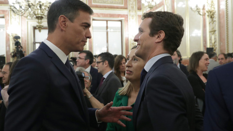 El presidente del Gobierno, Pedro Sánchez, conversa con el líder del PP, Pablo Casado, en presencia de la presidenta del Congreso, Ana Pastor, en el Salón de los Pasos Perdidos poco antes de la presentación de los actos conmemorativos del cuarenta ani