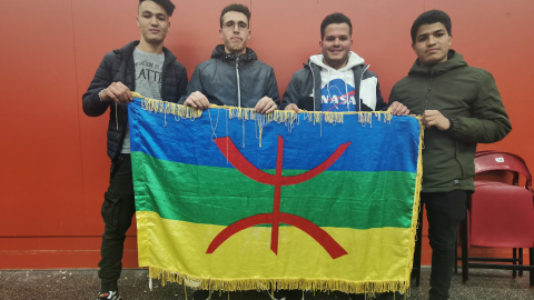 Unos jóvenes sostienen una bandera con los colores amazighs. QUERALT CASTILLO.