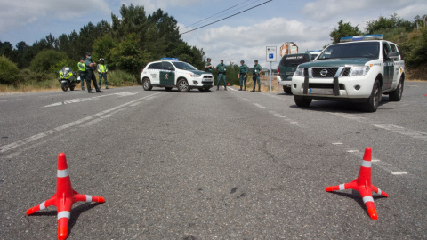 Agentes de la Guardia Civil en el tramo de la carretera LU-633, en el término municipal de Portomarín (Lugo), donde han sido movilizados también el 061, los Bomberos de Chantada, GES de Monterroso y Protección Civil y TEDAX después del accidente en e