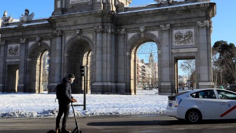 Un hombre circula con su patinete eléctrico por la madrileña calle Alcalá tras el paso de la borrasca Filomena.