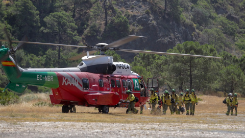 Bomberos que han estado trabajando toda la noche en el incendio forestal del Pujerra, llegan en helicóptero al puesto de mando a 09 de junio del 2022 en Pujerra (Málaga, Andalucía, España)