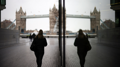 Una mujer camina cerca del Tower Bridge en Londres, Reino Unido