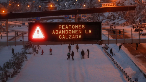 Varios ciudadanos caminan y juegan con la nieve en mitad de la M-30 de Madrid.