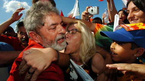 Una manifestante abraza y trata de besar a Lula. REUTERS/Diego Vara