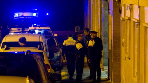 Agentes de los Mossos de Escuadra custodian la puerta de la casa de la calle Nápoles de Terrassa donde dos personas han muerto en un tiroteo. La hipótesis con la que trabajan los Moss es que una o varias personas entraron en la vivienda y dispararon a l