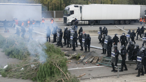 13/11/2019 - Mossos d'Esquadra davant d'una barricada d'arbres fumejant col·locada per tallar l'AP-7 el novembre de 2019.