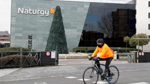 Un ciclista pasa ante la sede de la compañía energética Naturgy en Madrid. EFE/J.J. Guillén