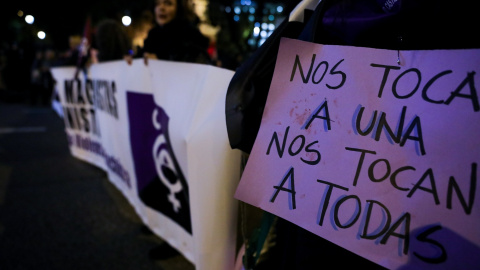 Una mujer sostiene un cartel en el que se lee "nos tocan a una, nos tocan a todas" en una manifestación feminista en Madrid.