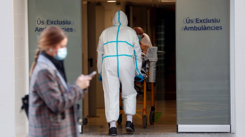 Un sanitario traslada a un enfermo en el Hospital Clínico de València.