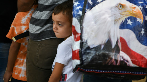 Un niño migrante de Guatemala de cinco años y su familia esperan con otros solicitantes de asilo, liberados tras ser detenidos en la frontera de EEUU con México.- REUTERS