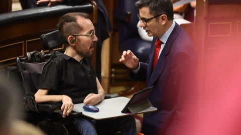 El portavoz de Unidas Podemos en el Congreso, Pablo Echenique (i), y el ministro de Presidencia, Félix Bolaños, conversan en una sesión de control, en el Congreso de los Diputados. E.P./Eduardo Parra