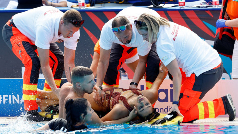 La española Andrea Fuentes saca a la nadadora Anita Álvarez del agua con la ayuda de los servicios de emergencia.