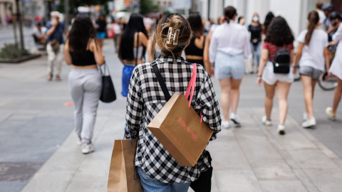 21/06/2022-Una mujer pasea con bolsas por la Gran Vía, a 21 de junio, en Madrid