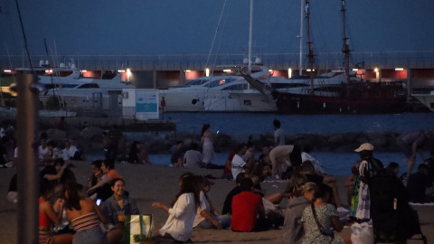 Un grup de gent sopa a la platja del Somorrostro de Barcelona a la revetlla de Sant Joan.