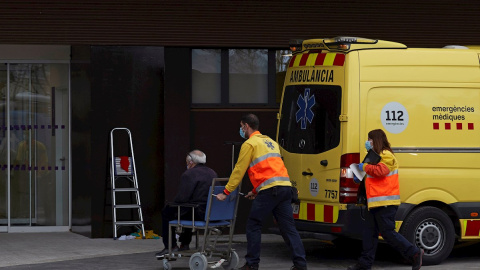 Dos técnicos de emergencias trasladan a un paciente al nuevo "hospital satélite" del Hospital Universitario de Bellvitge este lunes.