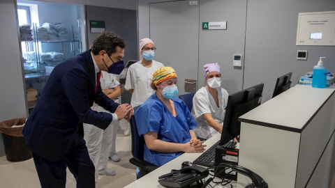 El presidente de la Junta, Juanma Moreno, junto al personal sanitario del nuevo Hospital de Emergencia Covid-19, construido en el antiguo Hospital Militar Vigil de Quiñones en Sevilla, que ha entrado hoy en funcionamiento.