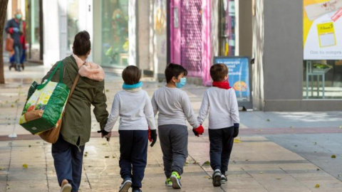 Fotografía de archivo de una madre y sus hijos tras hacer la compra en Zaragoza. EFE/ Javier Belver