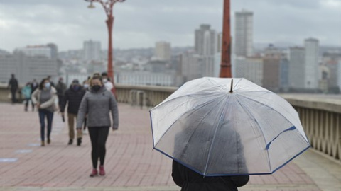 Una persona pasea con paraguas en el Paseo Marítimo, el mismo día del paso de la borrasca Justine convertida en ciclogénesis explosiva en A Coruña, Galicia.