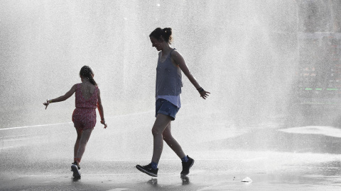 Dos personas se refrescan durante la ola de calor en Vitoria.