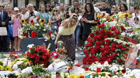 Grupo de personas depositan flores en el mosaico de Miró en Las Ramblas en recuerdo de las victimas de los atentados del 17-A. - EFE