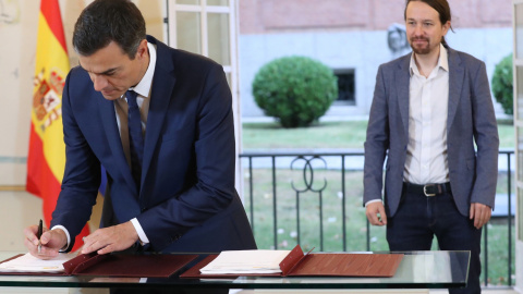 El presidente del Gobierno, Pedro Sánchez, y el secretario general de Podemos, Pablo Iglesias, firman en el Palacio de la Moncloa del acuerdo sobre el proyecto de ley de presupuestos para 2019. EFE/ Zipi