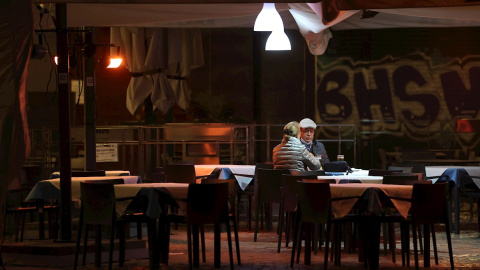 Dos personas toman algo en un bar de Madrid.