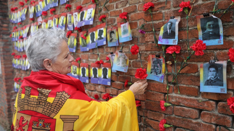 14/07/2022. Una mujer coloca una rosa en una pared durante una ofrenda floral y encuentro abierto entre familiares de las víctimas y estudiantes daneses del franquismo, en el cementerio de La Almudena, a 12 de abril de 2022, en Madrid