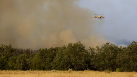 Un helicóptero trabaja en el incendio de Monsagro que los vientos cambiantes y el fuerte calor mantienen activo y dificultan su estabilización, este viernes en Salamanca.