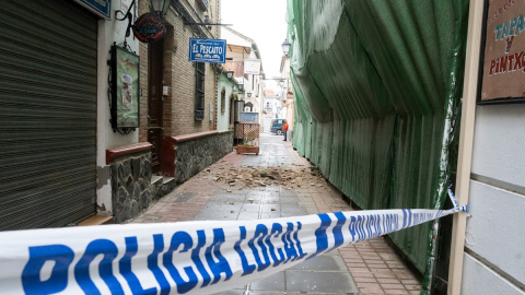 Imagen de una calle con cascotes caídos de los edificios en la localidad granadina de Santa Fé tras la treintena de terremotos que en las últimas horas han hecho temblar la Vega de Granada que han causado daños materiales y alerta a la población.