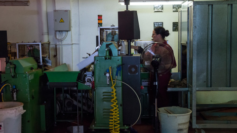 Una trabajadora maneja maquinaria en una fábrica de corchos en Girona, a 16 de junio de 2022.