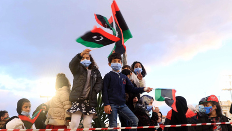 Varios niños sostienen banderas libias un día antes de las conmemoraciones del décimo aniversario del levantamiento contra el exlíder Muammar Gaddafi, en Trípoli, Libia, el 16 de febrero de 2021.